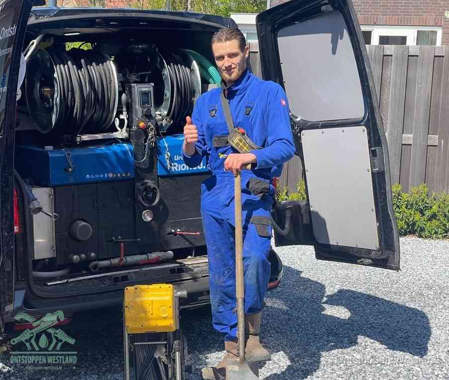Een tevreden monteur met opgestoken duim naast de bestelbus, slim ingrijpen bespaart kosten bij een verstopte afvoer in Westland