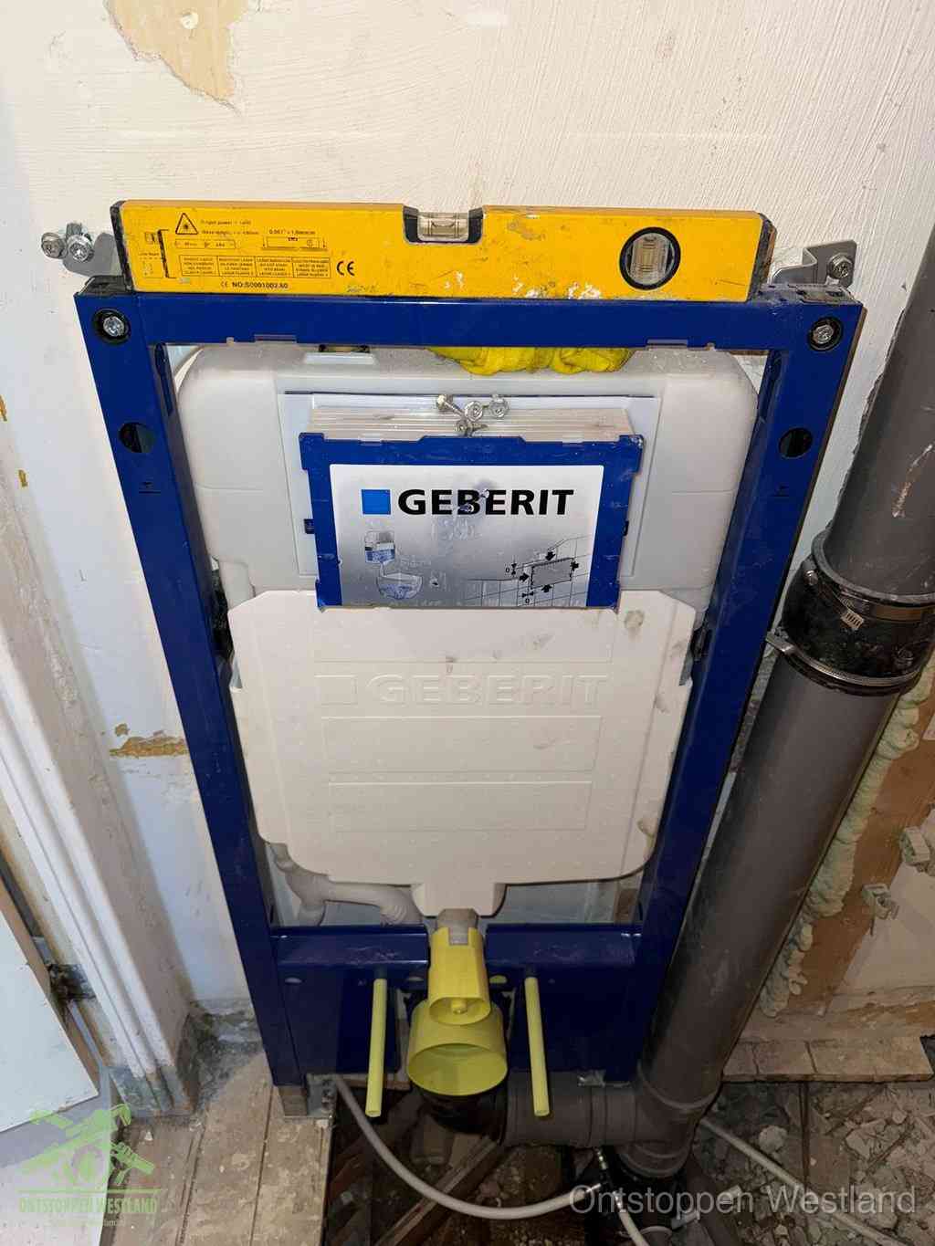 Een Geberit inbouwreservoir met frame voor een hangtoilet tegen de wand, met de afvoerbocht naar de vloer, kenmerkend voor een verstopt hangtoilet in Westland