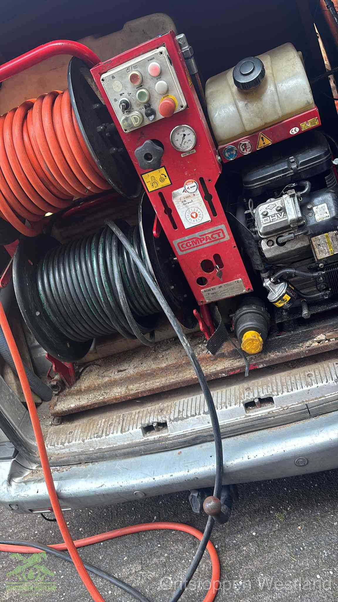 Een rood hogedruk-rioolreinigingstoestel met slangen in de laadbak van de bedrijfsbus, apparatuur voor een hardnekkige wc-verstopping in Westland