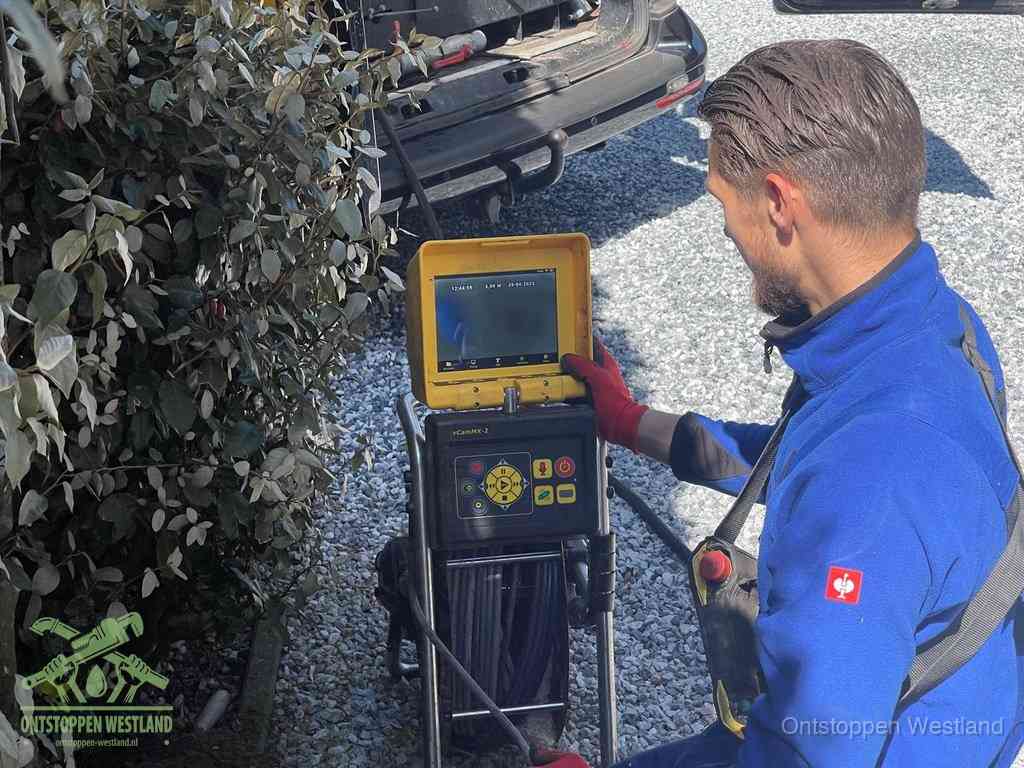 Monteur bedient een rioolinspectiecamera met monitor voor rioolinspectie in Westland