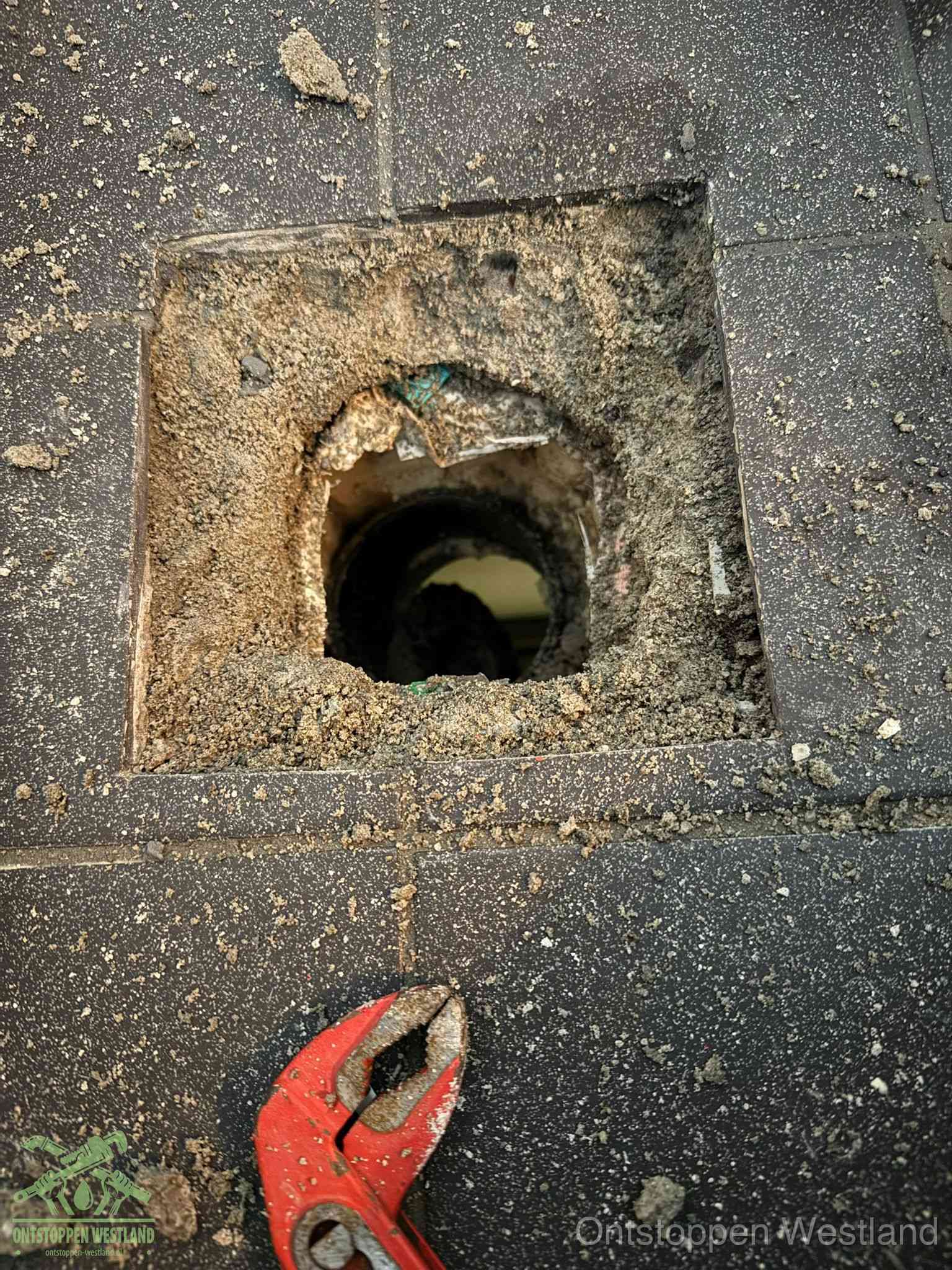Geopend rioolputje op de erfgrens dat laat zien wie eigenaar is van de riolering in Westland
