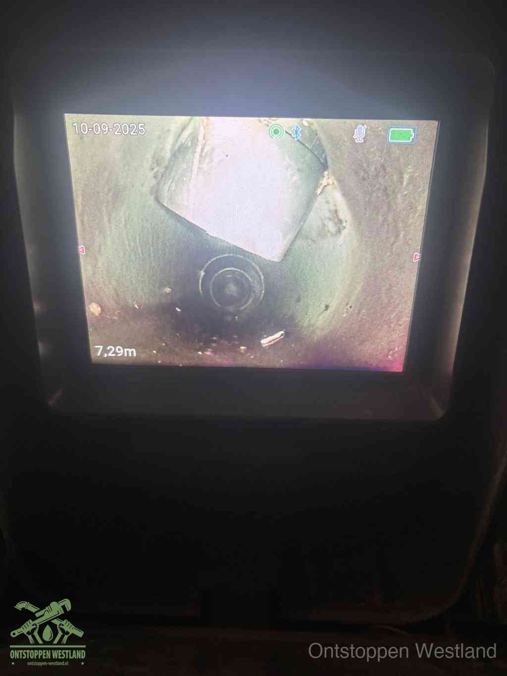 Camerabeeld van een verzakte rioolbuis diep onder de grond, een rioolverzakking in Westland