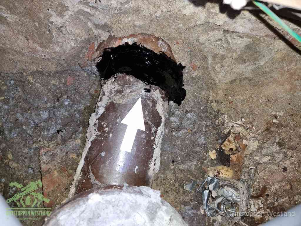 Een oude gres rioolbuis met een beschadigde koppeling onder de vloer, oorzaak van terugkerende structurele wc-problemen in Westland