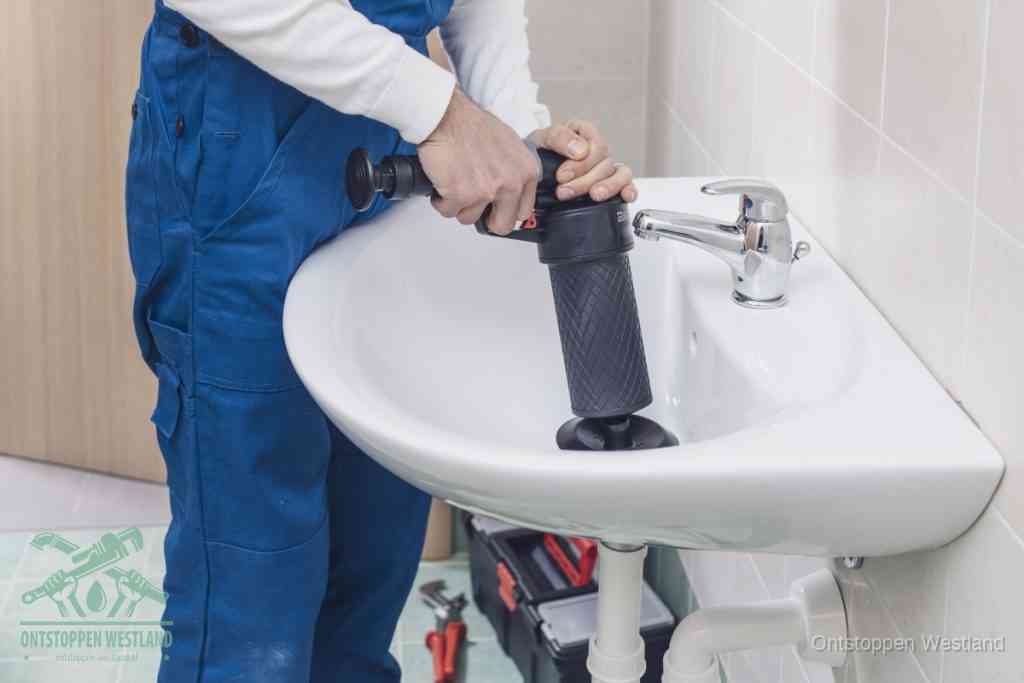 Een te ruwe doe-het-zelf poging met een hand-pomp op de afvoer van een badkamer-wastafel, een van de veelgemaakte fouten bij afvoer ontstoppen in Westland