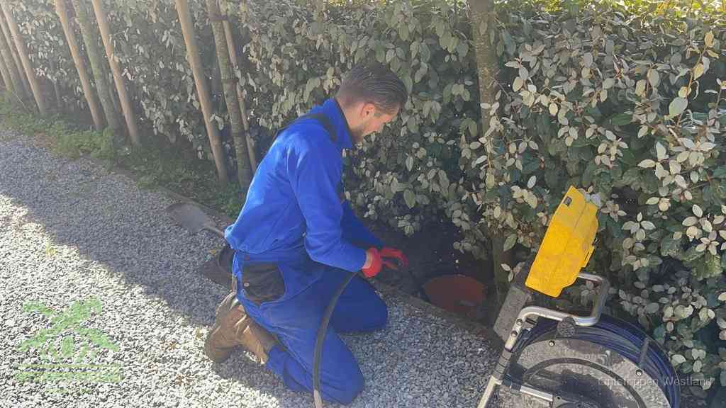 Monteur aan het werk bij een rioolput, de werkwijze voor riool ontstoppen in Westland
