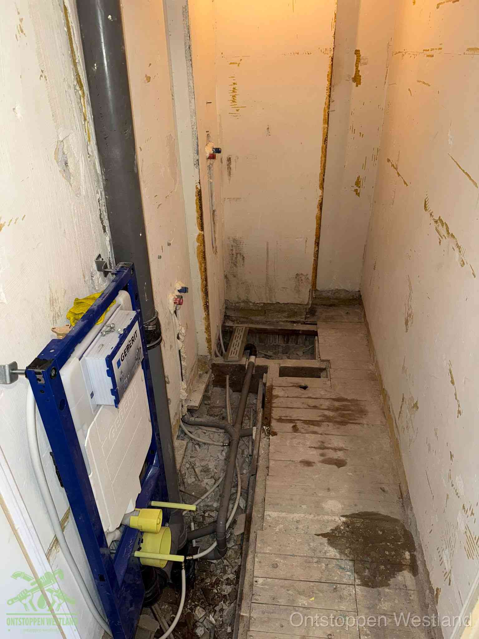 Een opgebroken toiletruimte tijdens renovatie met een Geberit inbouwreservoir en blootliggende oude afvoerleidingen, typisch voor oudere woningen in Westland